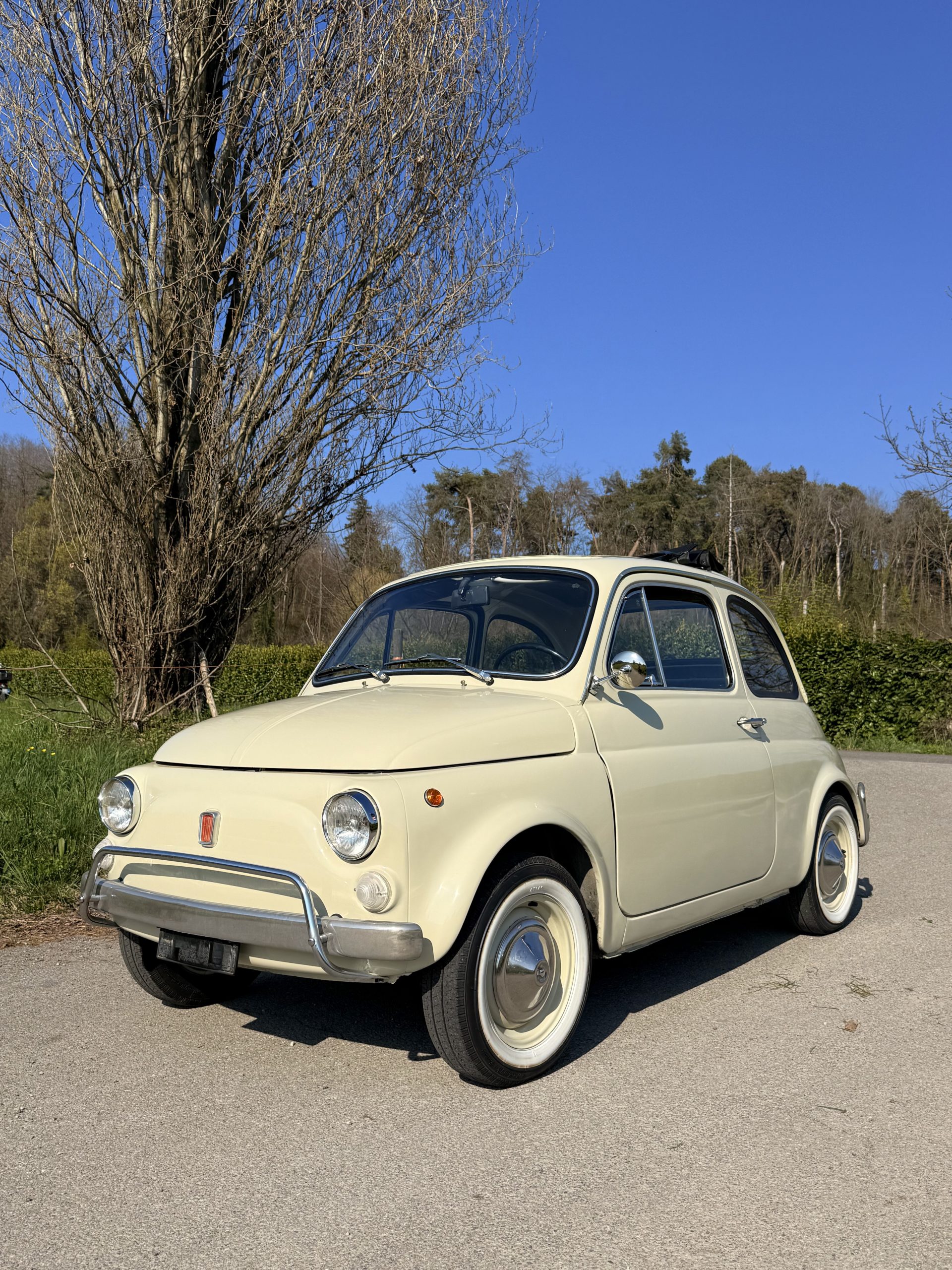 Fiat 500L color avorio parcheggiata in campagna, dettaglio dei cerchi con bande bianche