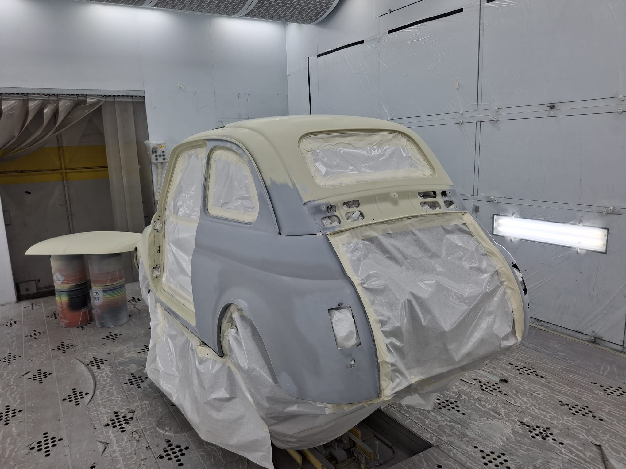 Portiera della Fiat 500L durante la verniciatura in cabina di restauro