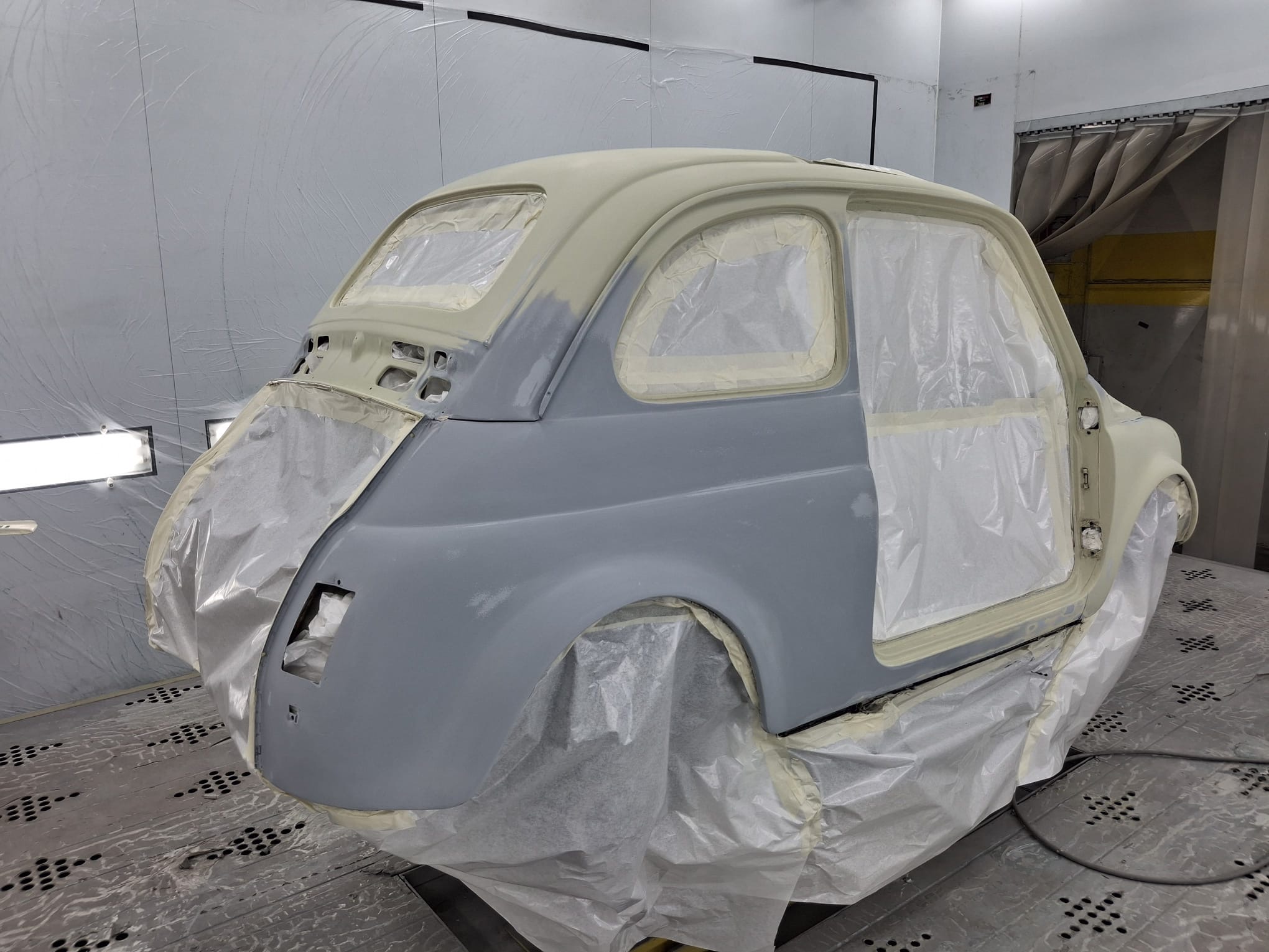 Fiat 500L durante il restauro: scocca in fase di verniciatura, meta' grigio primer e meta' avorio